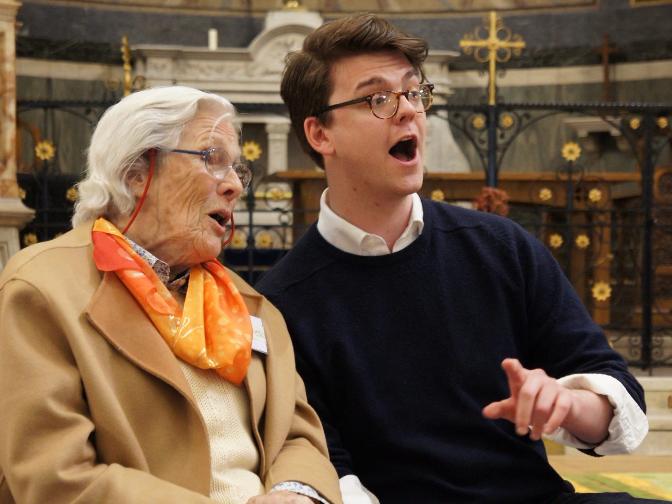 Two people singing together in a church